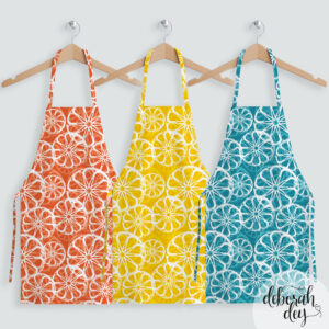 citrus fruit surface pattern designin orange, lemon and teal on aprons, designed by Deborah Dey